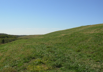 Capped closed sanitary landfill resembling a grassy hillside