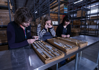 Three geologists examine rock core samples at McCracken Core Library and Research Center