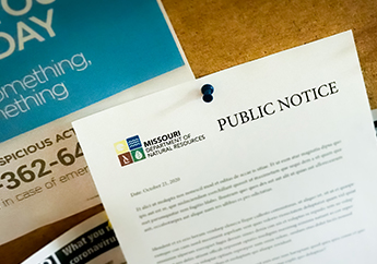 A public notice announcement thumbtacked to a bulletin board