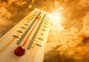 A thermometer shows a high temperature with the sun in the sky above it.