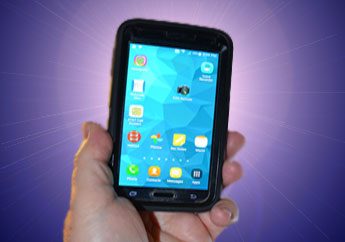 A hand holding a smartphone displaying various application icons.