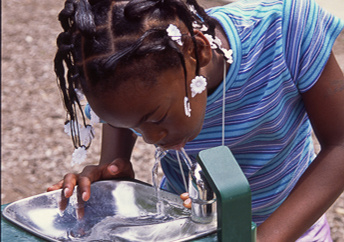 A girl getting a drink from a water fountain