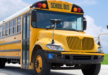 The outside of a generic yellow school bus, including the front view, bus door and half the loading side