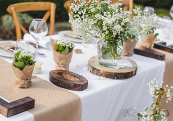 Recycled glass containers holding native flowers on a table at a wedding reception