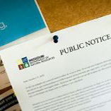 A public notice announcement thumbtacked to a bulletin board
