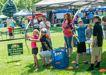 Children learning to shoot arrows at a target at a Missouri State Parks special event