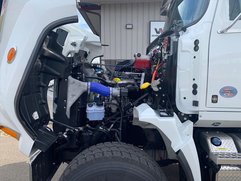 The front of a truck is swiveled open to expose its engine.