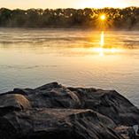 Sunrise barely peeking through a distant tree line at the Marion Access to the Missouri River