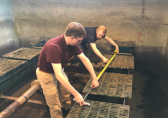 Two department staff conducting a filter bed media assessment to determine media layer integrity.