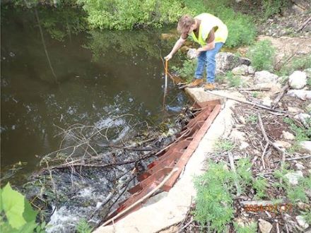 Intern Jacob Creed conducting a dam inspection