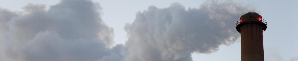 A cloud of steam escaping from the top of a smokestack