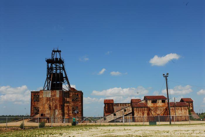 Old mining buildings surround by a fence.