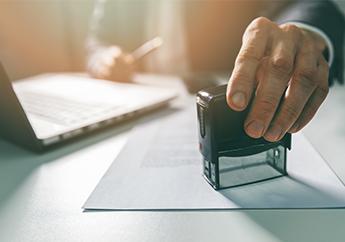 An individual sitting at a desk, data stamping an application form