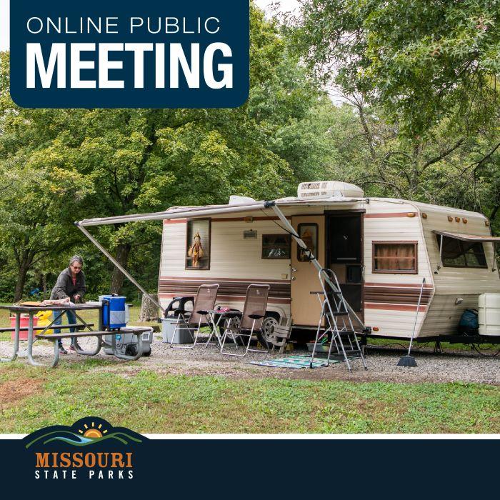 White camper with awning, door open. Two brown lawn chairs set up near a picnic table. Person standing by picnic table.