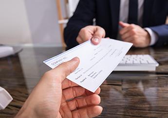 One individual handing a grant check to another individual