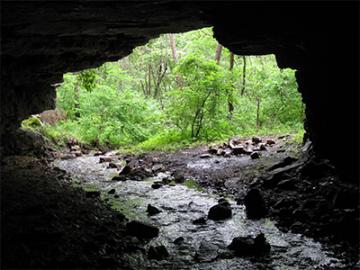 A stream flowing underneath a natural rock bridge