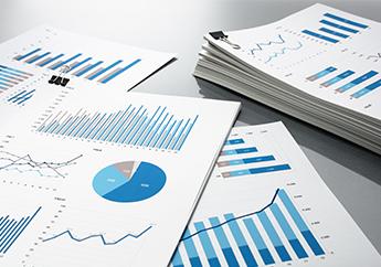 Several stacks of pie charts and graphs sitting on a table