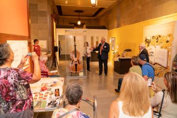 Dave Webb spoke to a group of about 30 friends, family and former Ozark Opry stars at the donation of Lee Mace’s famous bass fiddle to the Missouri State Museum