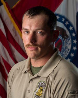 Headshot of Corporal Jason Walker April 2025 MoDNR Team Member of the Month. US and State Flag in background.