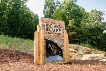 Rock and Wood entrance sign with bluff in metal, with text Echo Bluff State Park.
