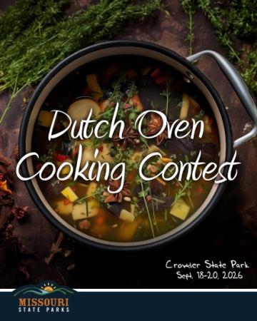 A Dutch Oven filled with veggies and broth sitting on a table surrounded by herbs